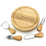 Personalised Christmas themed round cheeseboard engraved with the message "The Wilson Family". Pictured on a white background with a set of cheese utensils.