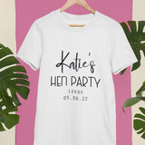 A personalised white hen party t-shirt with black text printed on the font. The text reads "Katie's Hen Party, Leeds, 05.06.22"