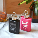 Personalised 1oz keyring hip flask featuring a stag design engraved on black for "Richard" and a hen design engraved on pink for "Louise".
