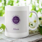 A personalised jubilee mug in white with the official emblem for the Queen's Platinum Jubilee 2022 printed on the front in purple.