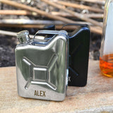 Personalised silver jerry can with the name "Alex" engraved at the front. Pictured outdoors with a bottle of spirit in the background.