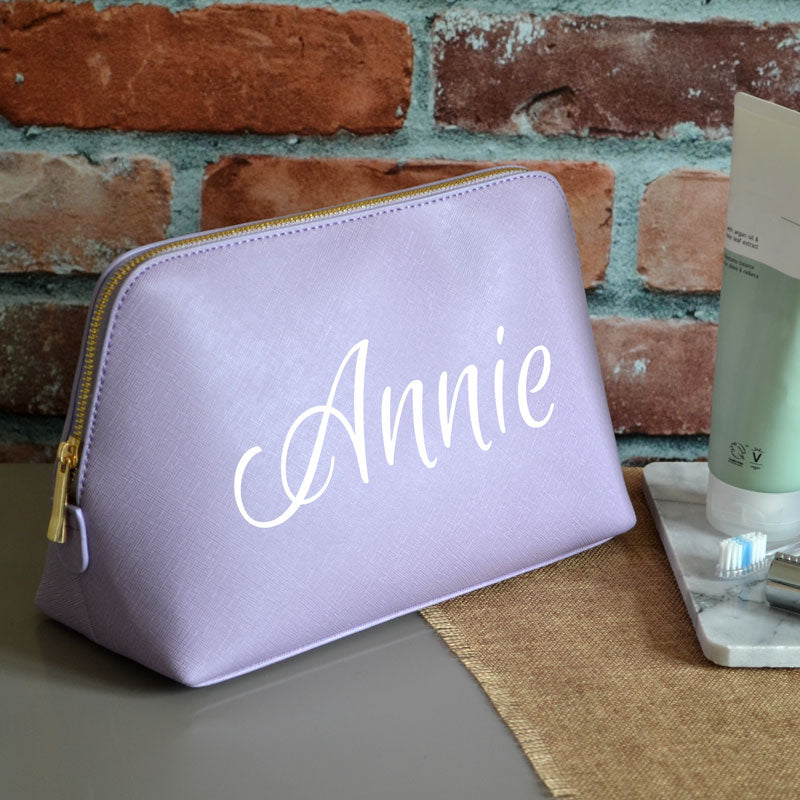 A personalised wash bag in purple with a name printed in white