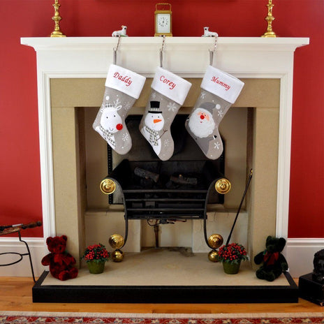 Silver stockings for kids and toddlers hanging on fireplace