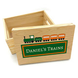 A personalised toy box for storing toy trains. The box is wooden with a green and orange train printed on the lid.