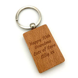 A picture of a personalised wooden rectangular keyring on a white background with a short message engraved on to the tag.