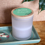 A personalised be my bridesmaid candle in a glass jar with a bamboo lid. The design is printed in mint green on the candle lid.
