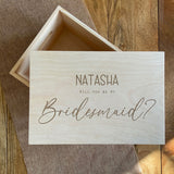 A personalised bridesmaid gift box made from natural wood with an engraved message on the lid.