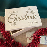 A close up of a wooden Christmas Eve box with a personalised design engraved on the lid.