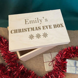 A wooden box engraved with a festive design featuring text and winter snowflakes.