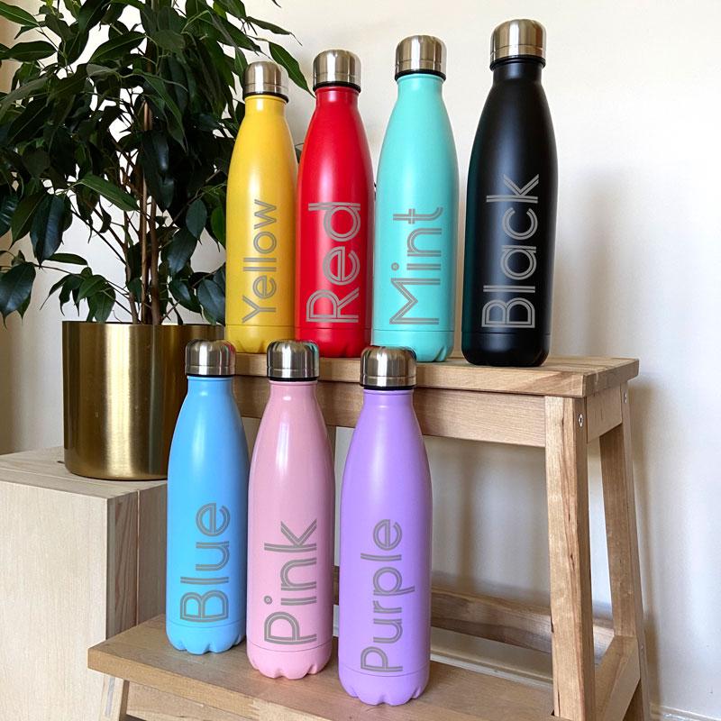 Coloured water bottles stacked on a table