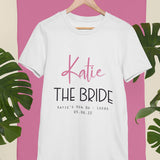 A personalised hen do t-shirt in white with pink and black lettering. The shirt has the name "Katie" printed above the words "The Bride"