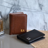 Personalised black leather wallet and personalised brown leather wallet on a table