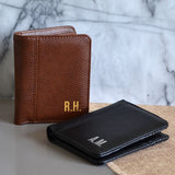Two personalised leather wallets in black and tan. The wallets have metallic initials printed in the corners.