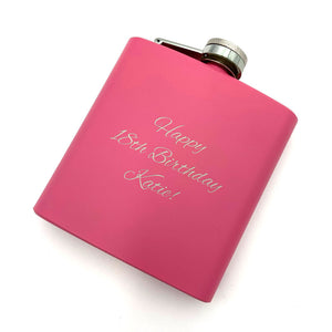 A personalised hip flask with a mat pink coating and an engraved message.