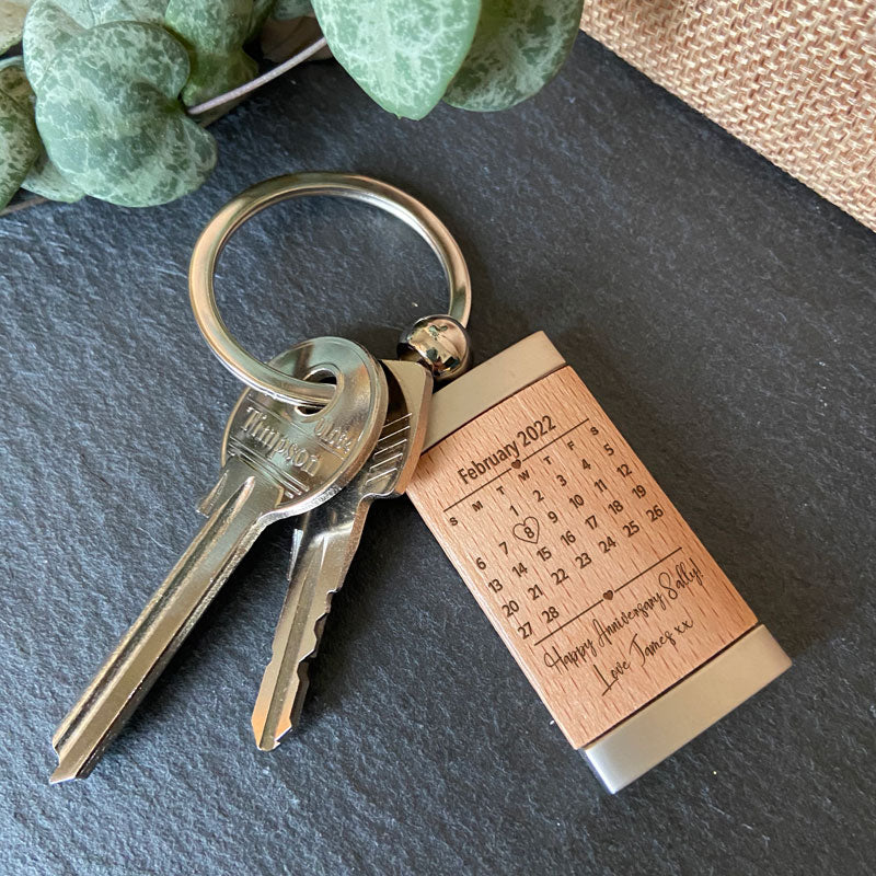 A personalised anniversary keyring. The keyring is made from wood and metal and has an engraved design highlighting the date of your anniversary and has space for a message.