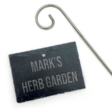 A personalised slate sign with an engraved message for marking plants in the garden.