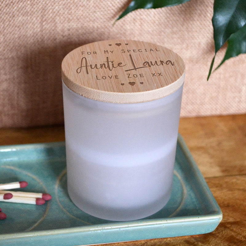 A personalised candle with a bamboo lid. The bamboo lid has a 