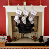 Silver stockings for kids and toddlers hanging on fireplace