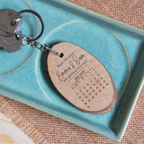 A personalised Save the Date keyring made from a real tree slice. The wooden keyring is engraved with your names and the date of your wedding.