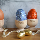 Two personalised wooden egg cups with engraved names